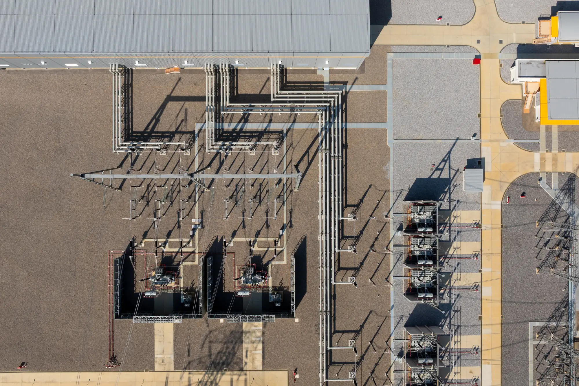 Aerial view of a commercial electrical substation with transformers and switchgear serving an industrial site