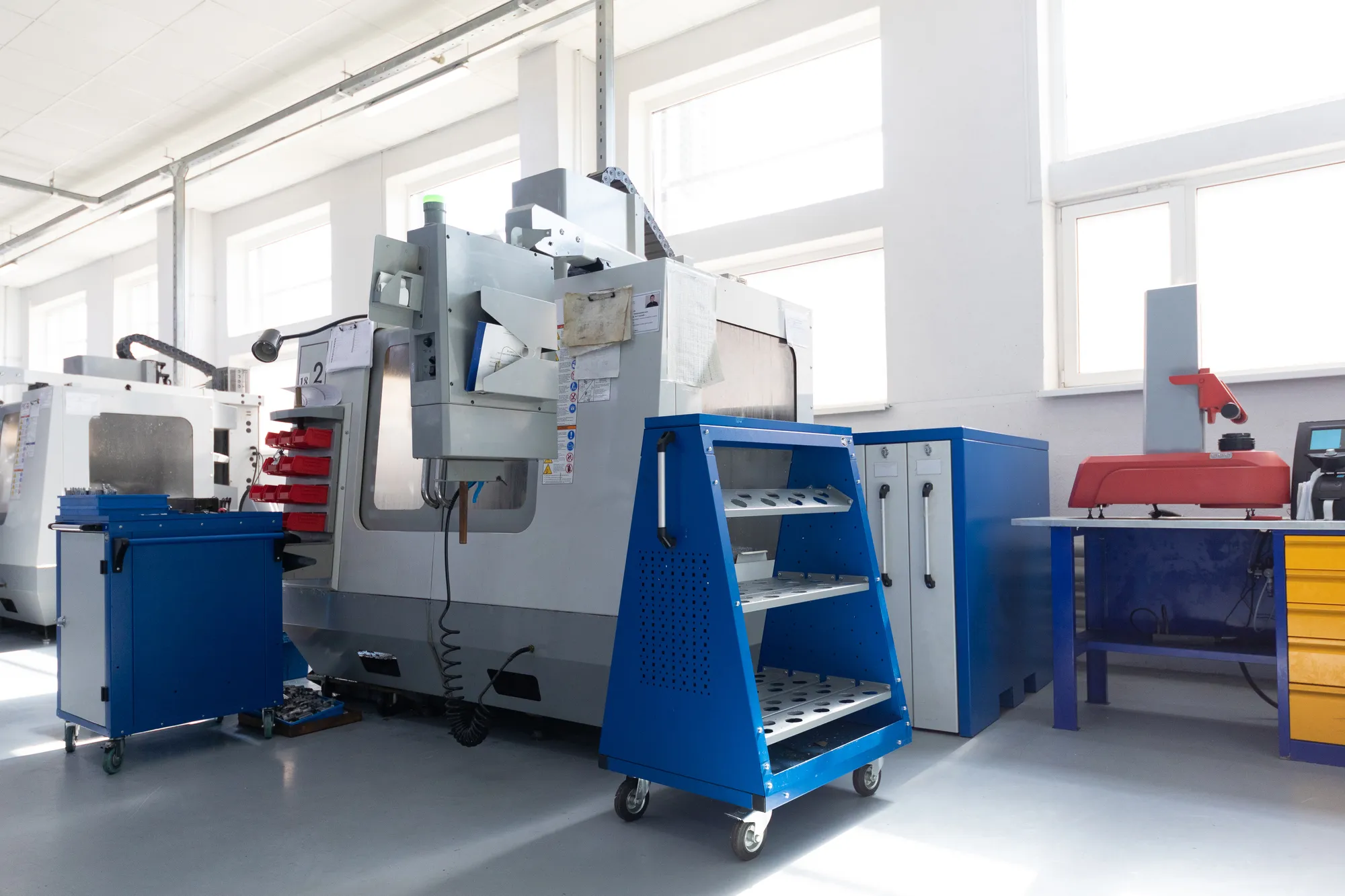 CNC machining center and tool carts on a bright machine shop floor